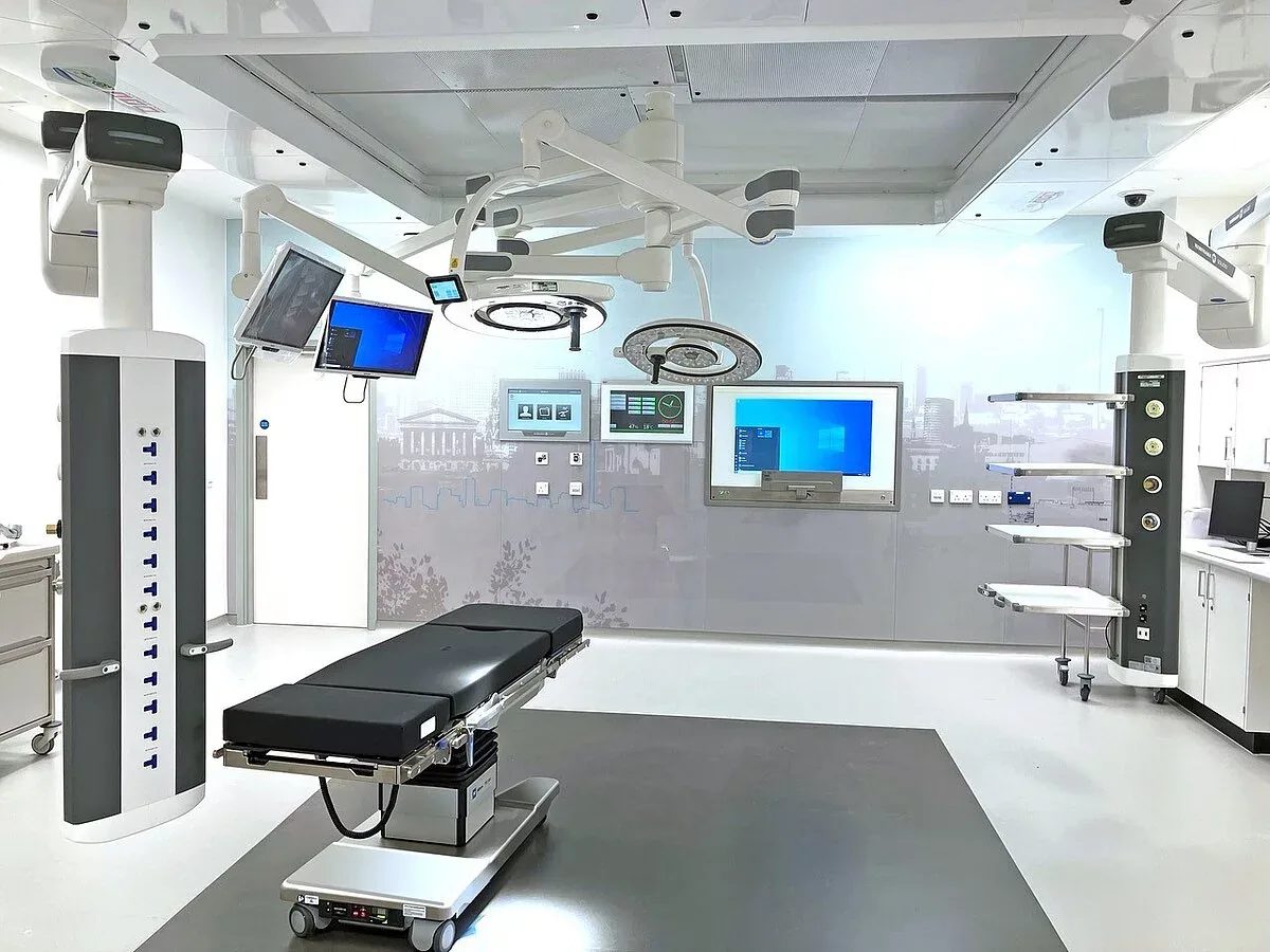 A modern operating theatre at The Harborne Hospital, Birmingham, with image-guided surgical displays and a Birmingham skyline wall graphic