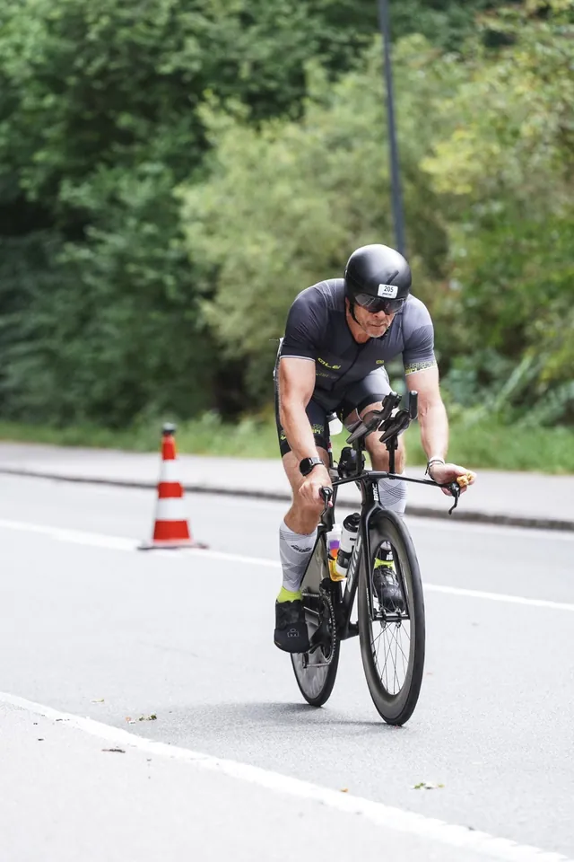 Martin, race number 205, riding a tree-lined section of the Ironman Copenhagen bike course