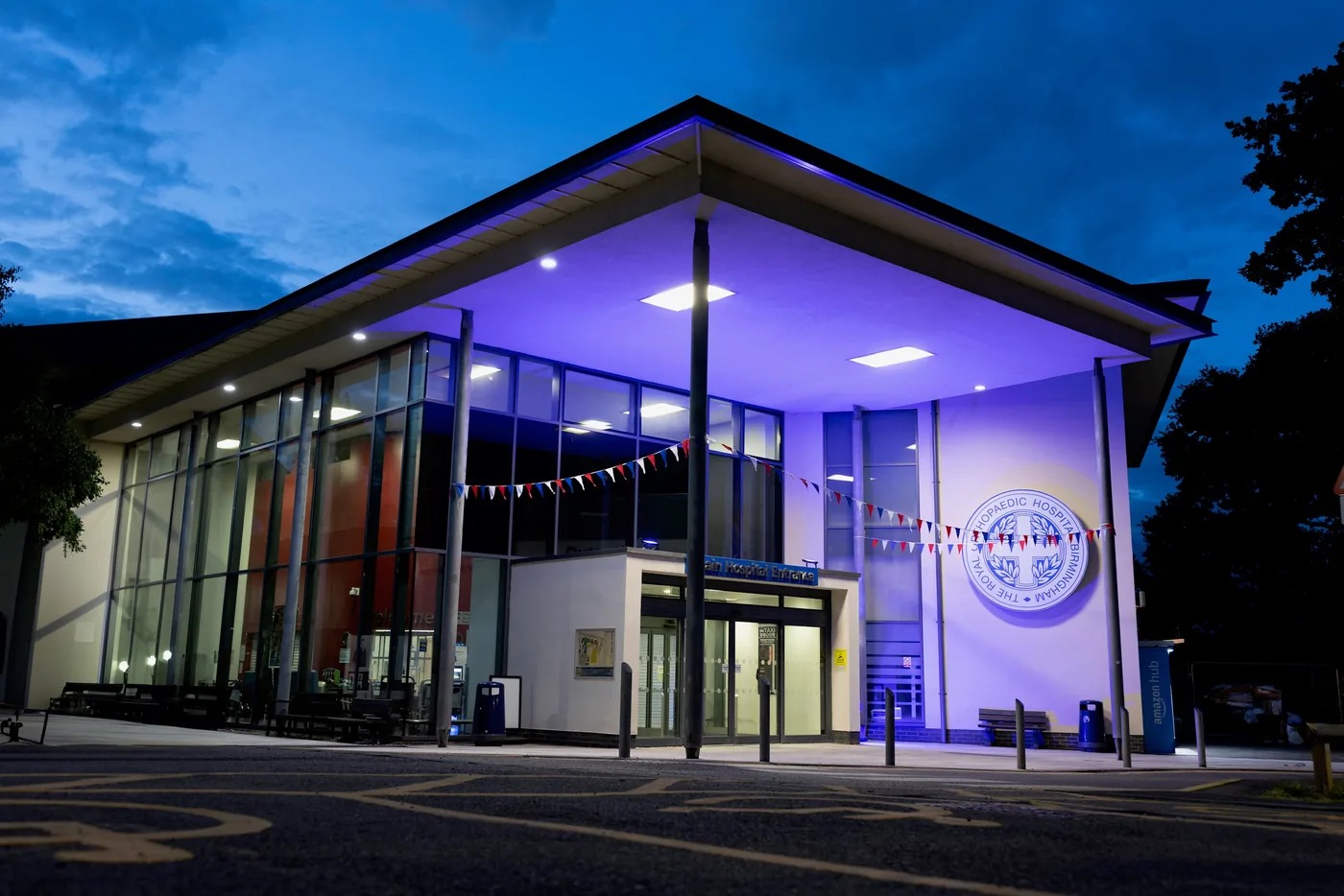 The Royal Orthopaedic Hospital, Birmingham, lit at dusk with the hospital crest beside the main entrance